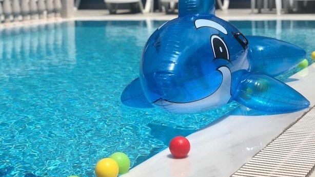 Una piscina amb un xupanet de tauró blau i pilotes de colors.