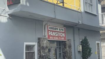 Ein Gebäude mit einem Schild, auf dem 'ERSOY CFE PANSIYON' und 'PANSIYON' Hotel steht.