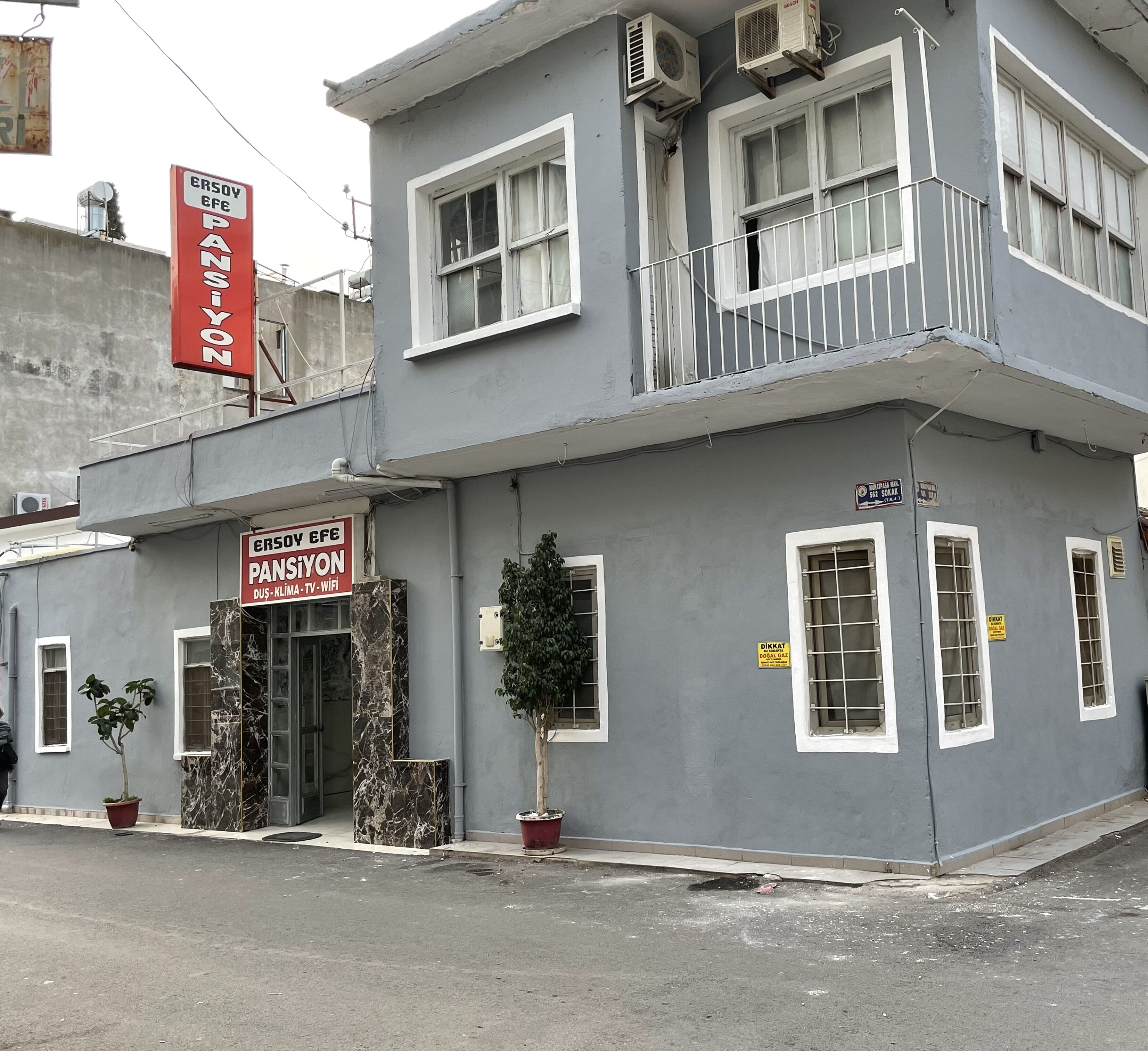 A two-story building with a sign for 'ERSOY EFE PANSIYON' and 'DUS-KLIMA-TV-WIFI'.