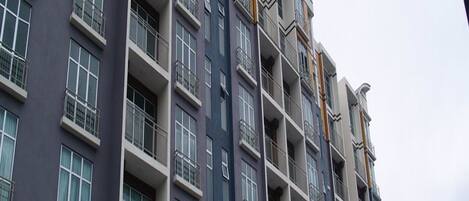 A multi-story residential building with balconies, large windows, and a flat facade.