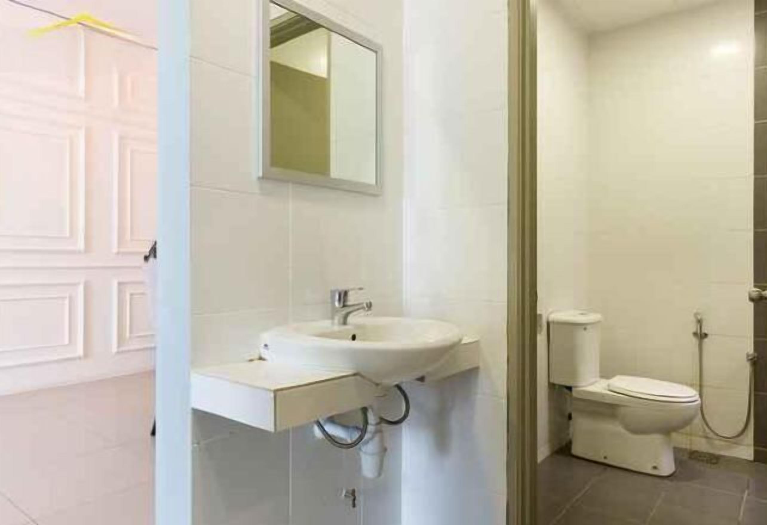 A bathroom with a white sink, mirror, toilet, and shower.