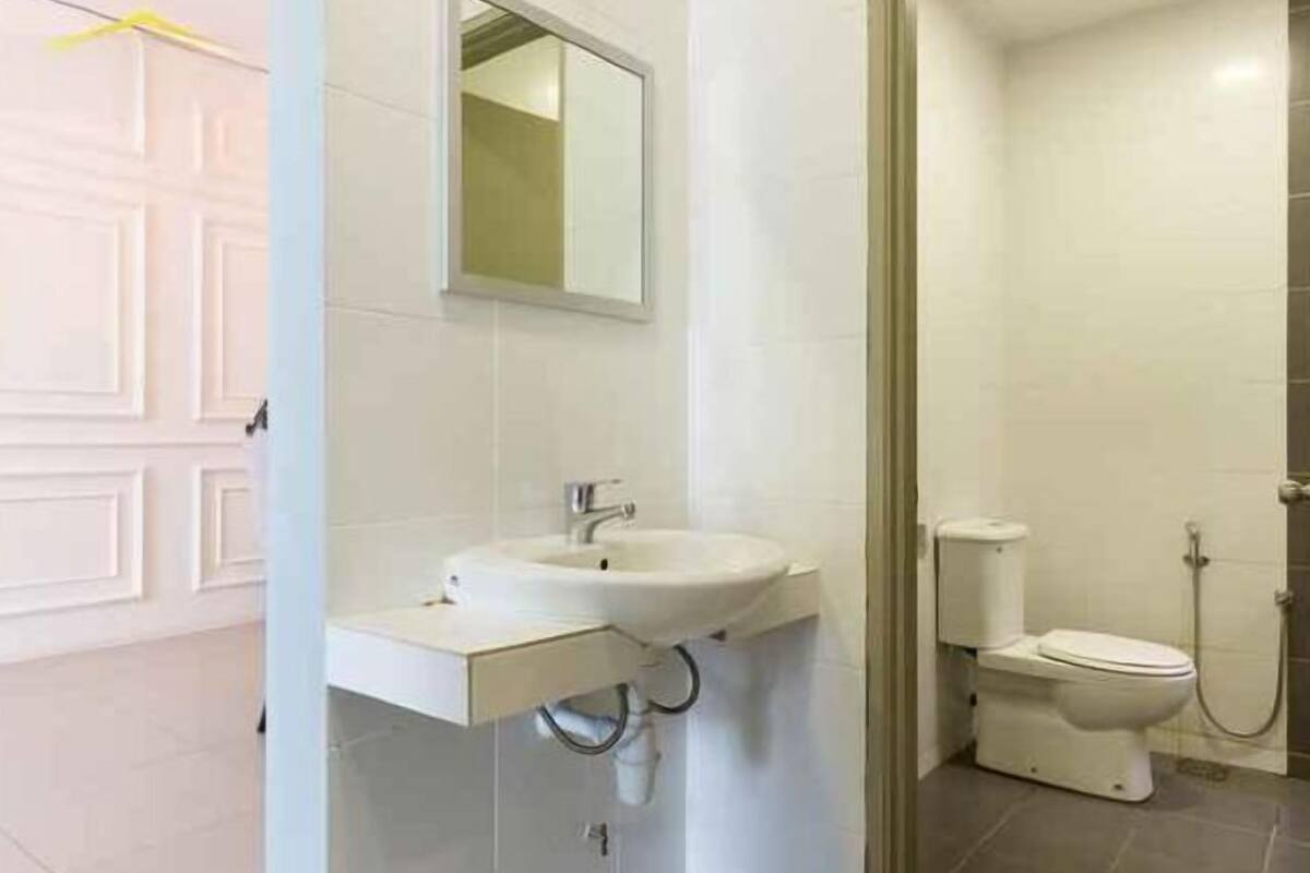 A bathroom with a white sink, mirror, toilet, and shower.