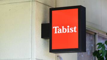 Ein Schild mit dem Wort 'Tabist' auf rotem Grund.