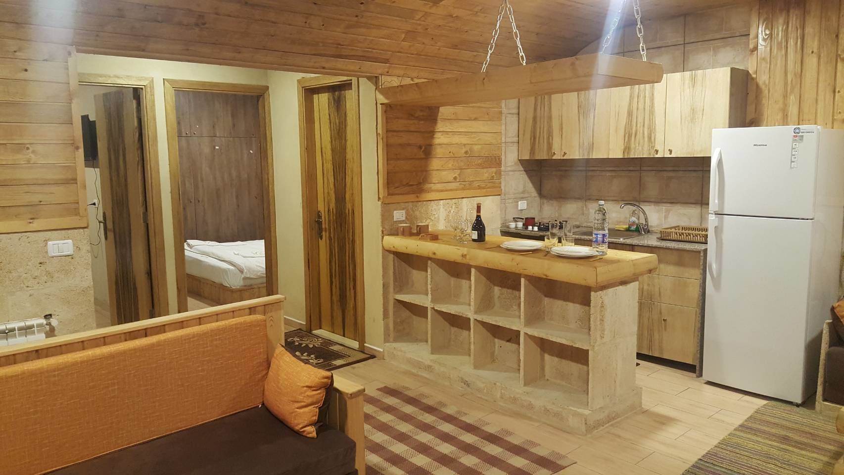 Una cocina compacta con armarios de madera, un lavaplatos empotrado y un refrigerador.