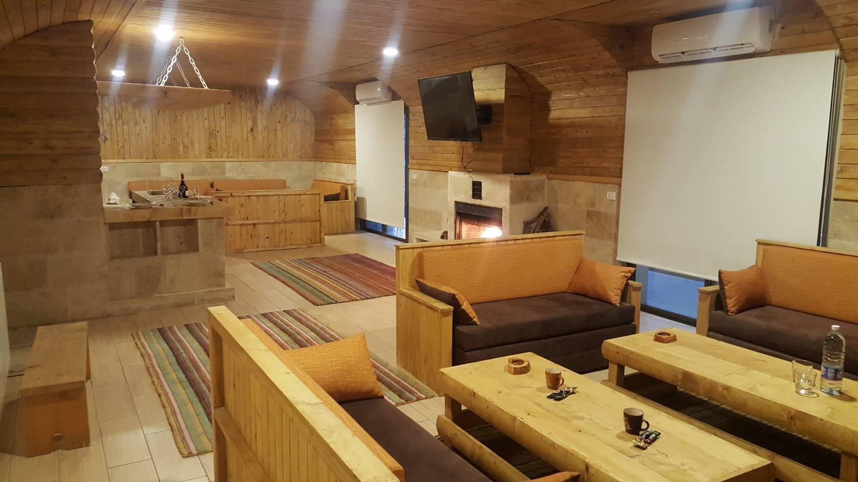 Un interior de cabaña acogedor con mobiliario de madera, chimenea y comedor.