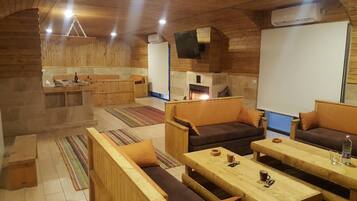 Un interior de cabaña acogedor con mobiliario de madera, chimenea y comedor.