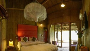 A spacious bedroom with a large bed, a wooden floor, a red headboard, and a view of the outdoors. - La Dao Spa Homestay (Ta Van)