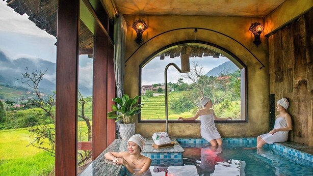 A spa area with a pool, a view of green fields, and a traditional architectural style. - La Dao Spa Homestay (Ta Van)