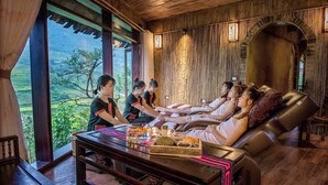 A spa room with a view of the countryside, wooden walls, and a massage table with towels. - La Dao Spa Homestay (Ta Van)