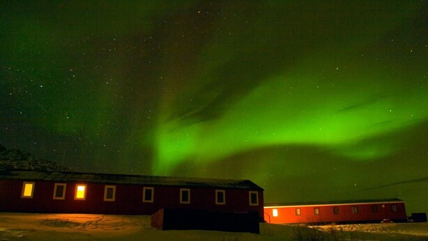 A building with multiple windows and a snow-covered ground. - Old Camp (Kangerlussuaq)