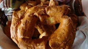 Ein Korb mit frisch gebackenem Brot auf einer Tischdecke.