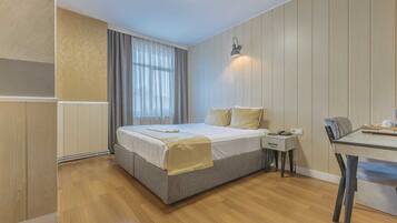 A bedroom with a bed, bedside table, and a desk with a chair.