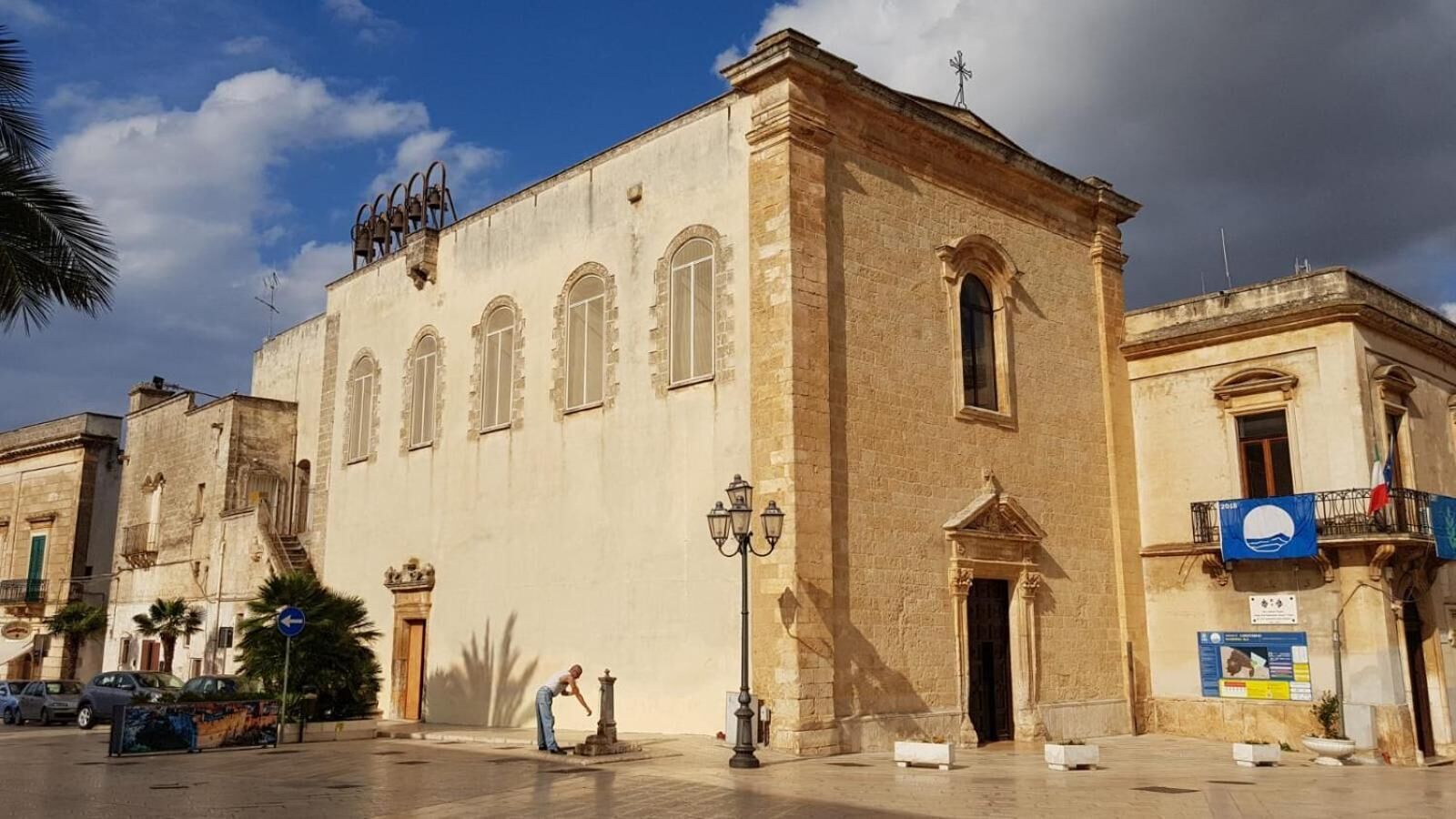 A historic building with a central entrance, arched windows, and a bell tower.