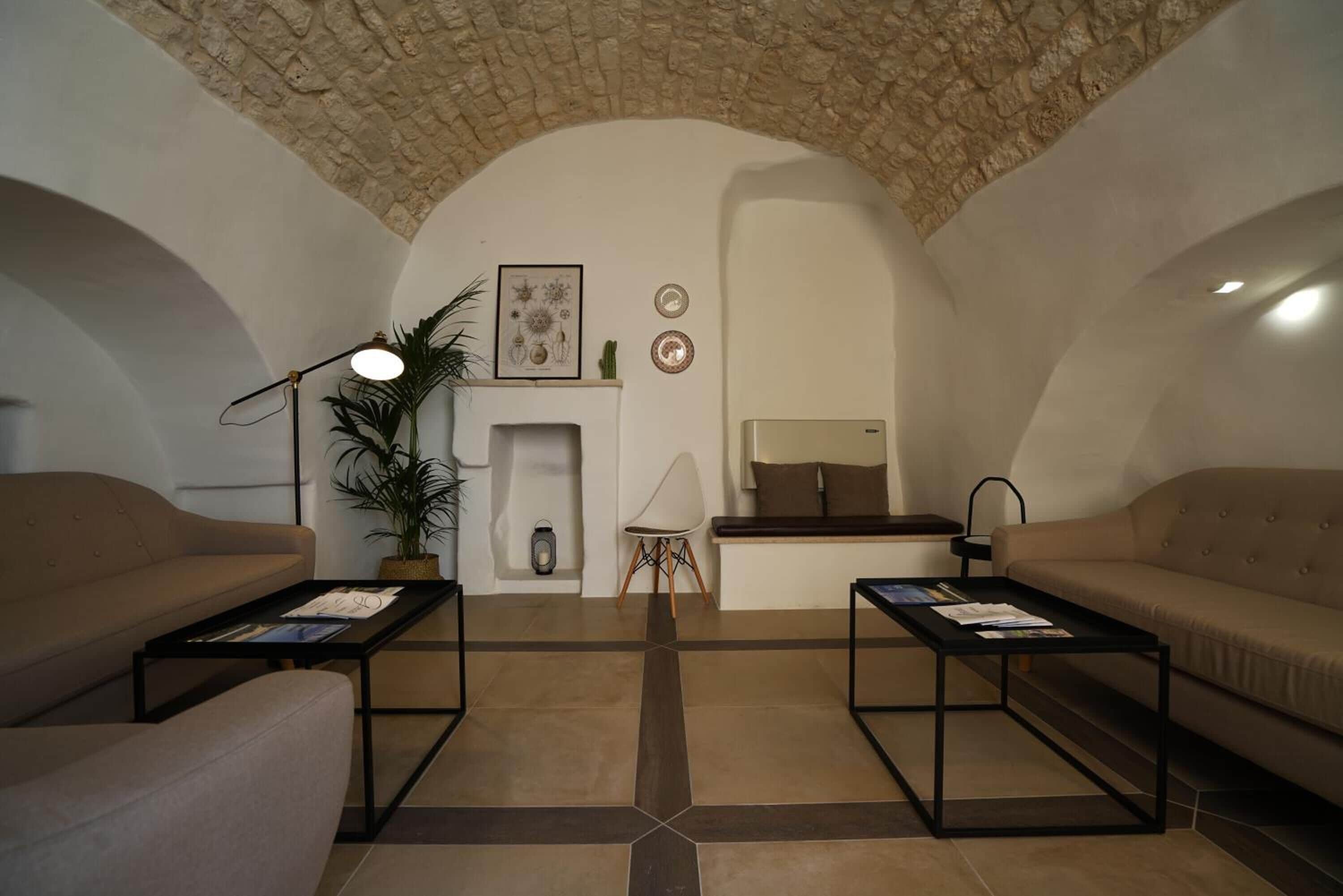 A living room with two sofas, a coffee table, a fireplace, and a stone ceiling.