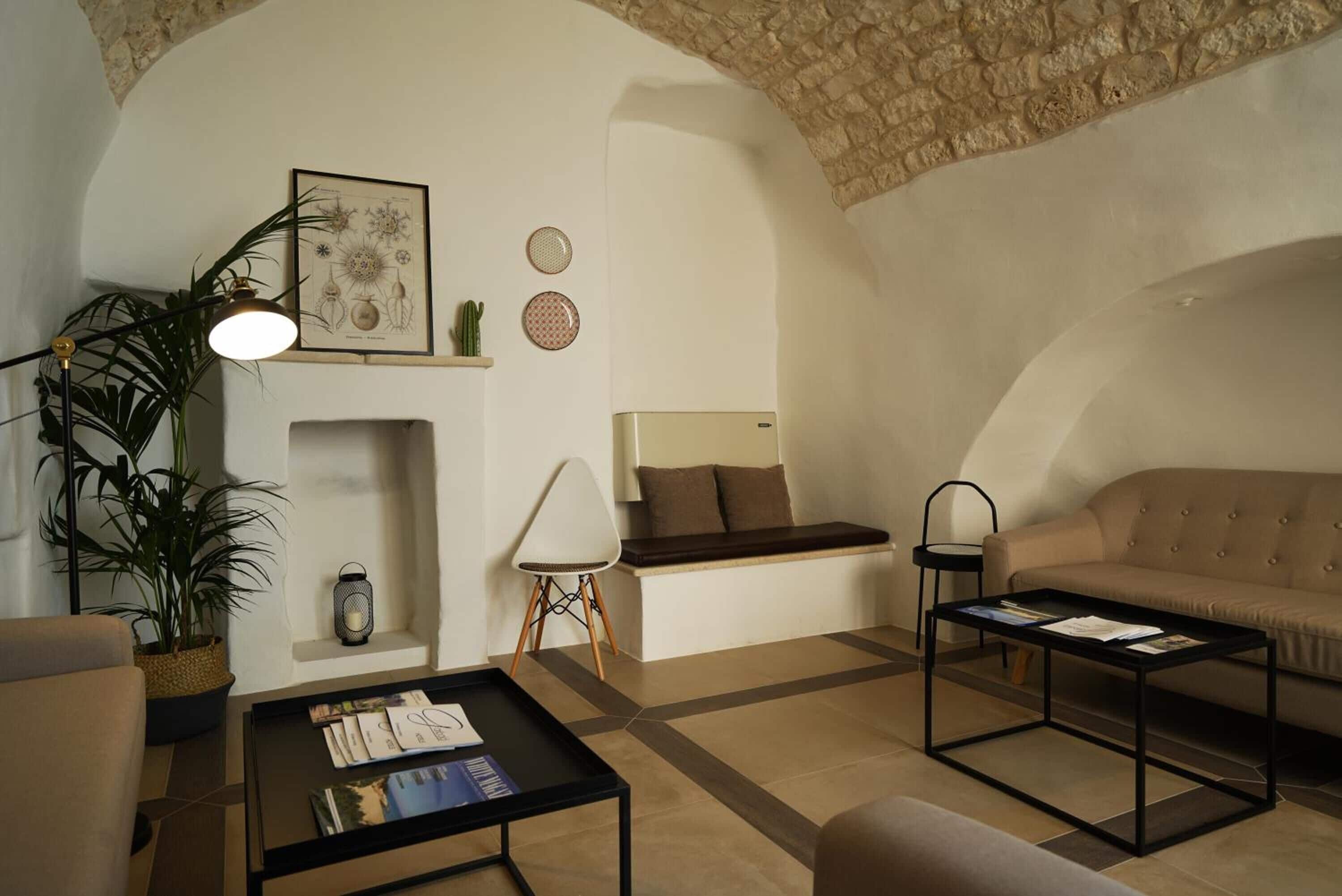 Un salon chaleureux avec un canapé, une table basse, une lampe, une plante et une cheminée.