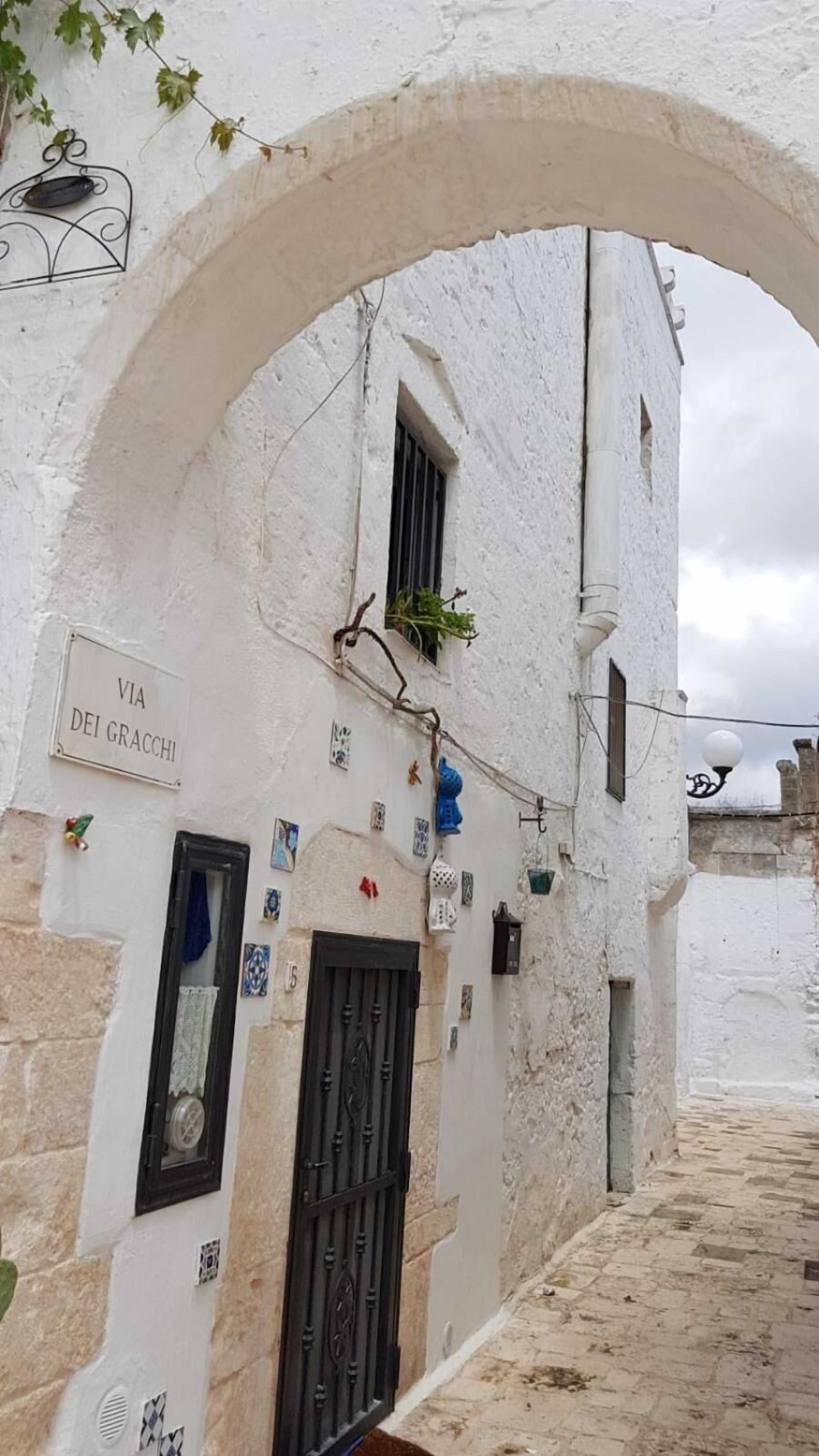 A white building with a sign reading "VIA DEI GRACCHI".
