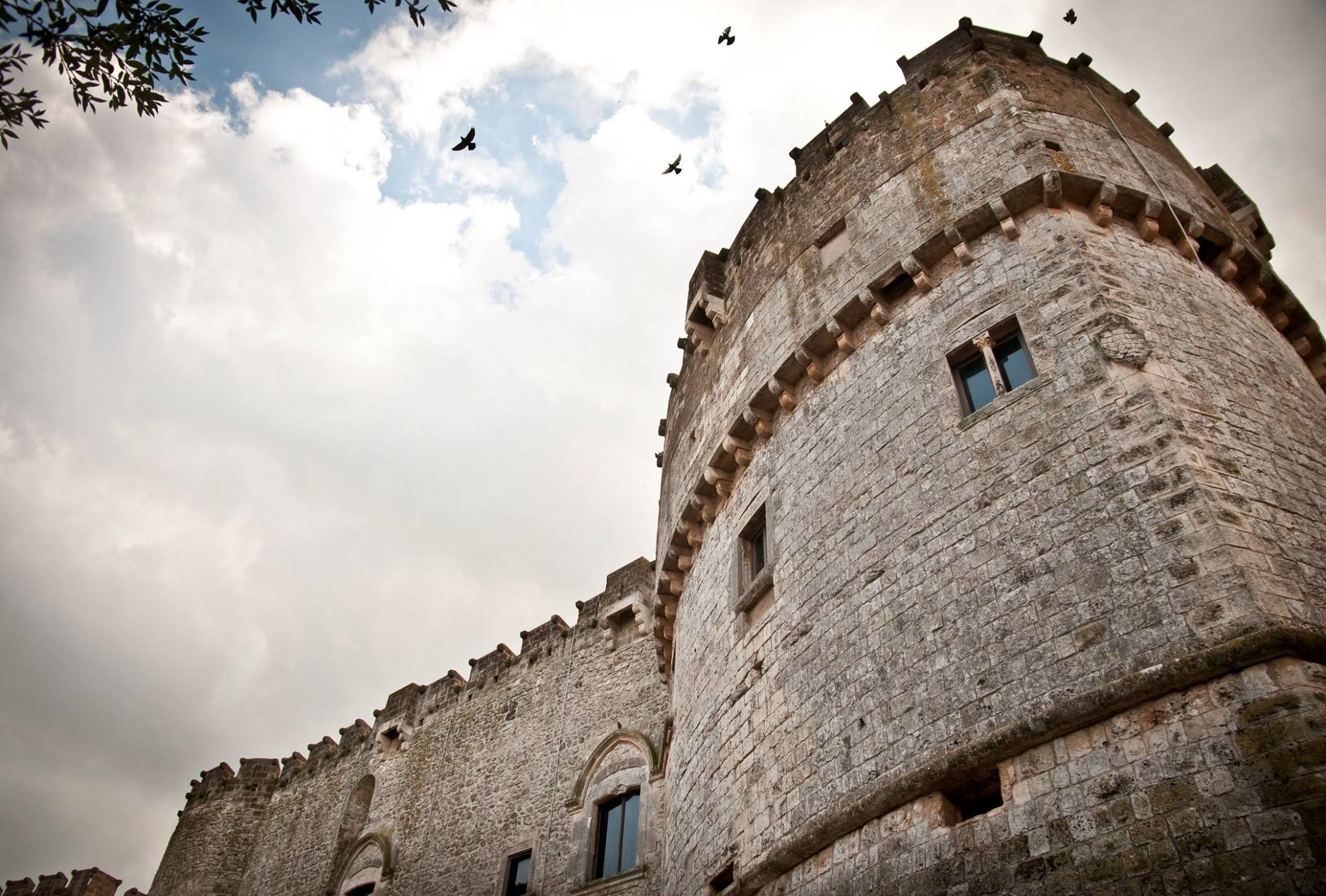 A historic stone building with arched windows and battlements.