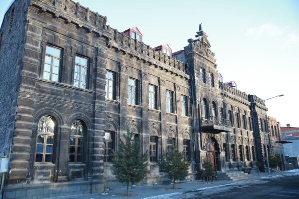 A historic building with ornate architectural details, large windows, and a prominent entrance. - Cheltikov Hotel (Kars)
