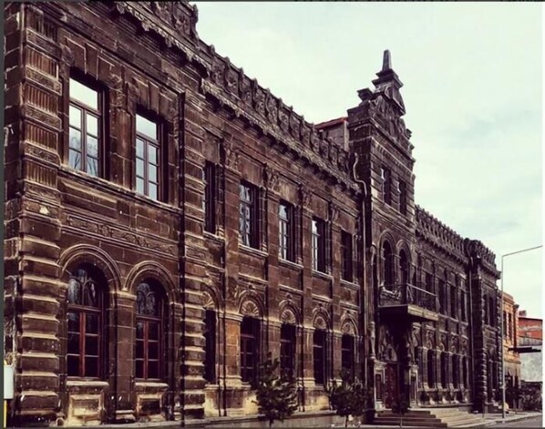 A large, historic building with multiple arched windows and detailed stonework.