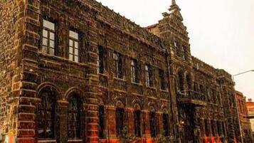 A historic building with a large central entrance, arched windows, and a prominent tower.