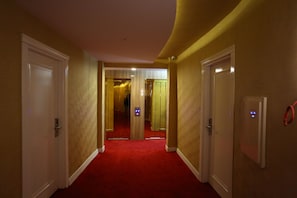 A hotel hallway with red carpet, white doors, and a security camera. - Bilgehan Hotel (Antalya)