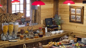 A breakfast buffet with various food items and a rustic wooden interior.