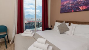 A hotel room with a large bed, a view of a cityscape, and a balcony with red curtains. - B&B Metropolitan (Naples)