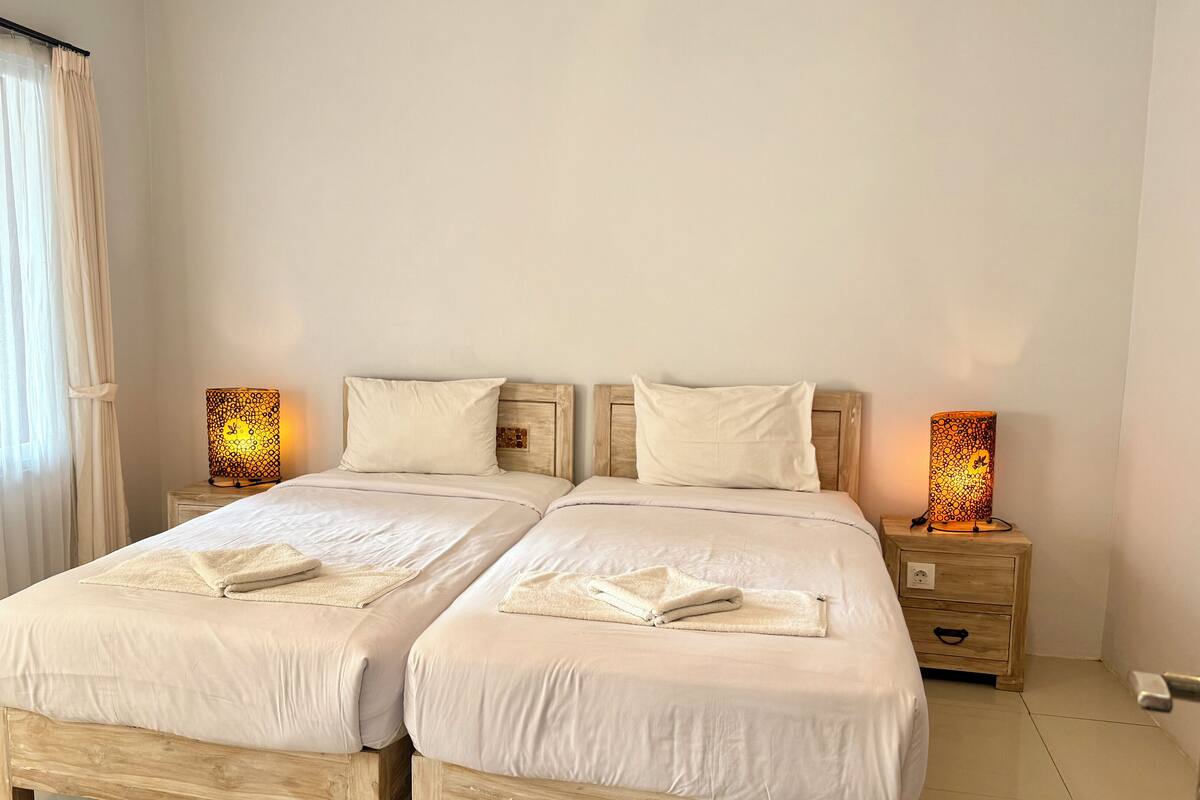 A double bed with two bedside tables, each with a lamp.