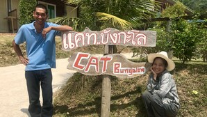 Un letrero de madera con texto tailandés y la palabra 'Bungalow' en inglés, que indica una zona de bungalows.