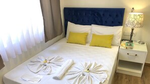 Cama bem arrumada com toalhas e uma camisa branca dobrada sobre ela.