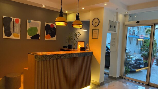 Uma mesa de recepção com um letreiro que diz 'TIP BOX', um relógio e arte abstrata na parede.