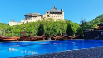 Una piscina al aire libre, sillones reclinables de piscina