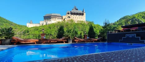 Una piscina al aire libre, sillones reclinables de piscina