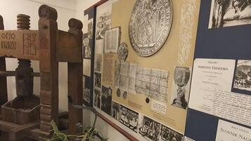 A historical exhibit with a wooden press, documents, and photographs.