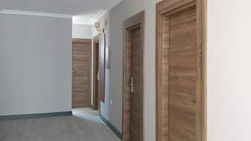 Um corredor com portas de madeira e piso em tons claros.