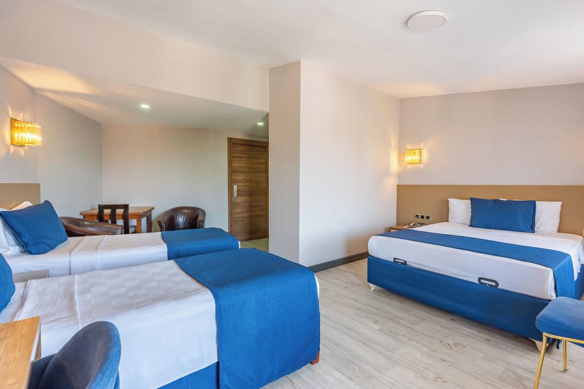 A hotel room with two beds, a desk, and a chair.