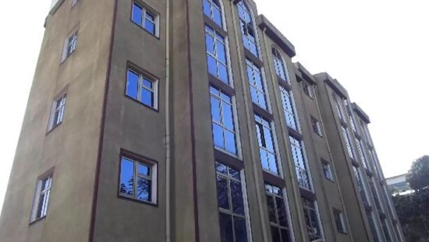 A multi-story building with a symmetrical facade, large windows, and a flat roof. - The Lions Den Hotel (Addis Ababa)