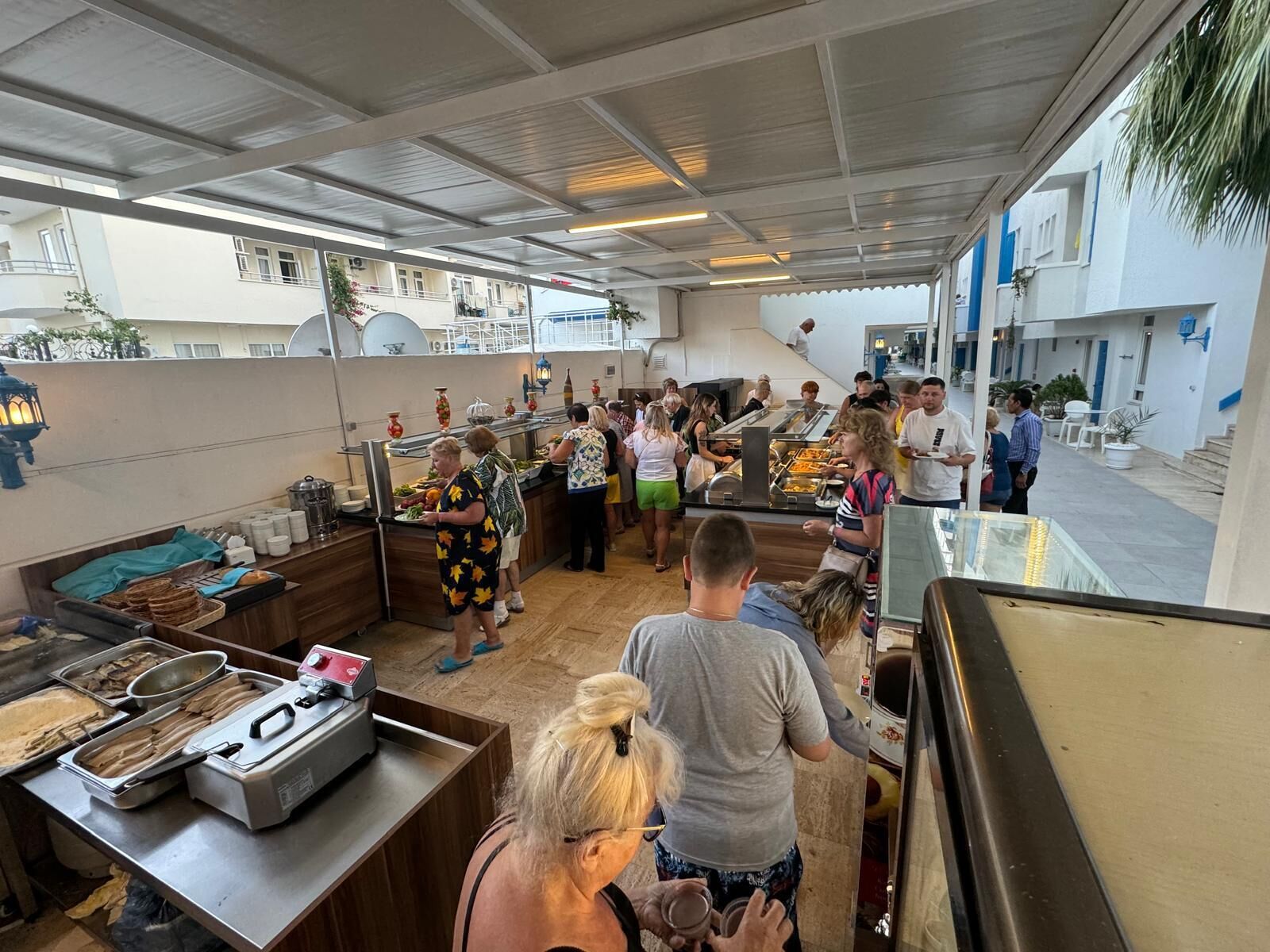 A buffet area with food service counters and a crowd of people.