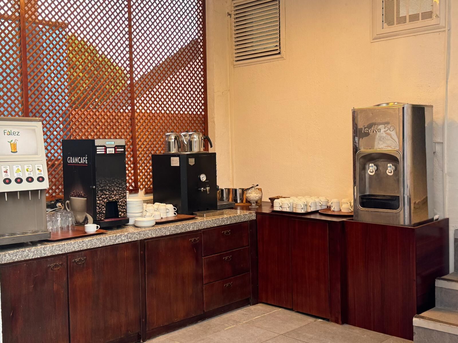 A kitchenette with a coffee machine, a water dispenser, and a coffee grinder.