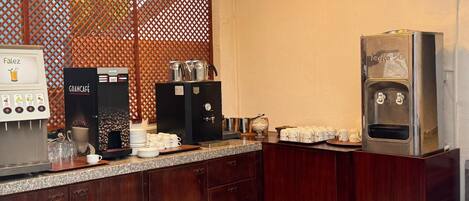 A kitchenette with a coffee machine, a water dispenser, and a coffee grinder.