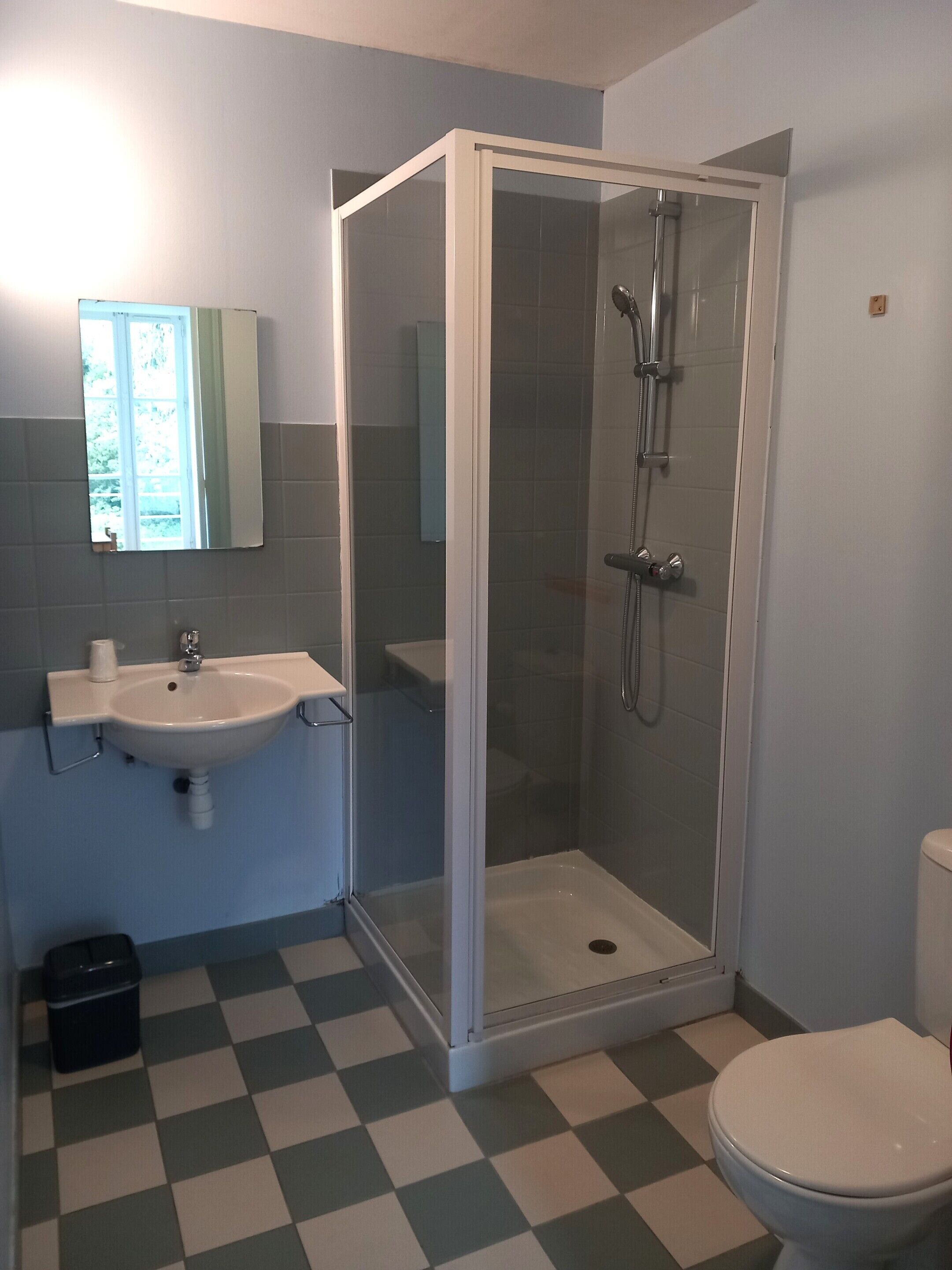 Une salle de bain avec une douche à parois de verre, un lavabo et des toilettes.