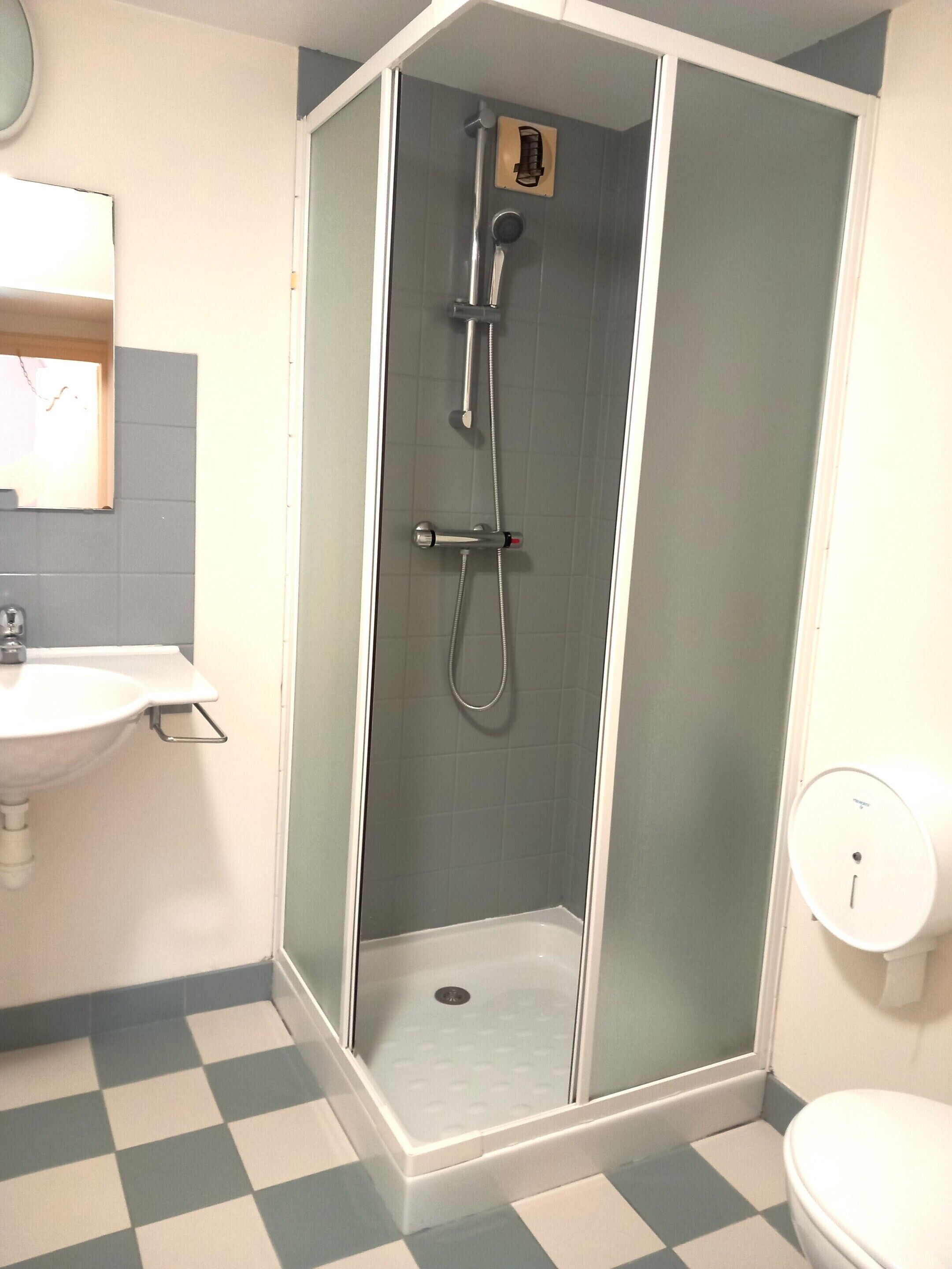 Un baño con cabina de ducha, lavabo e inodoro.