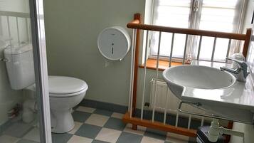 Un bagno con il water, un lavandino e una zona doccia.
