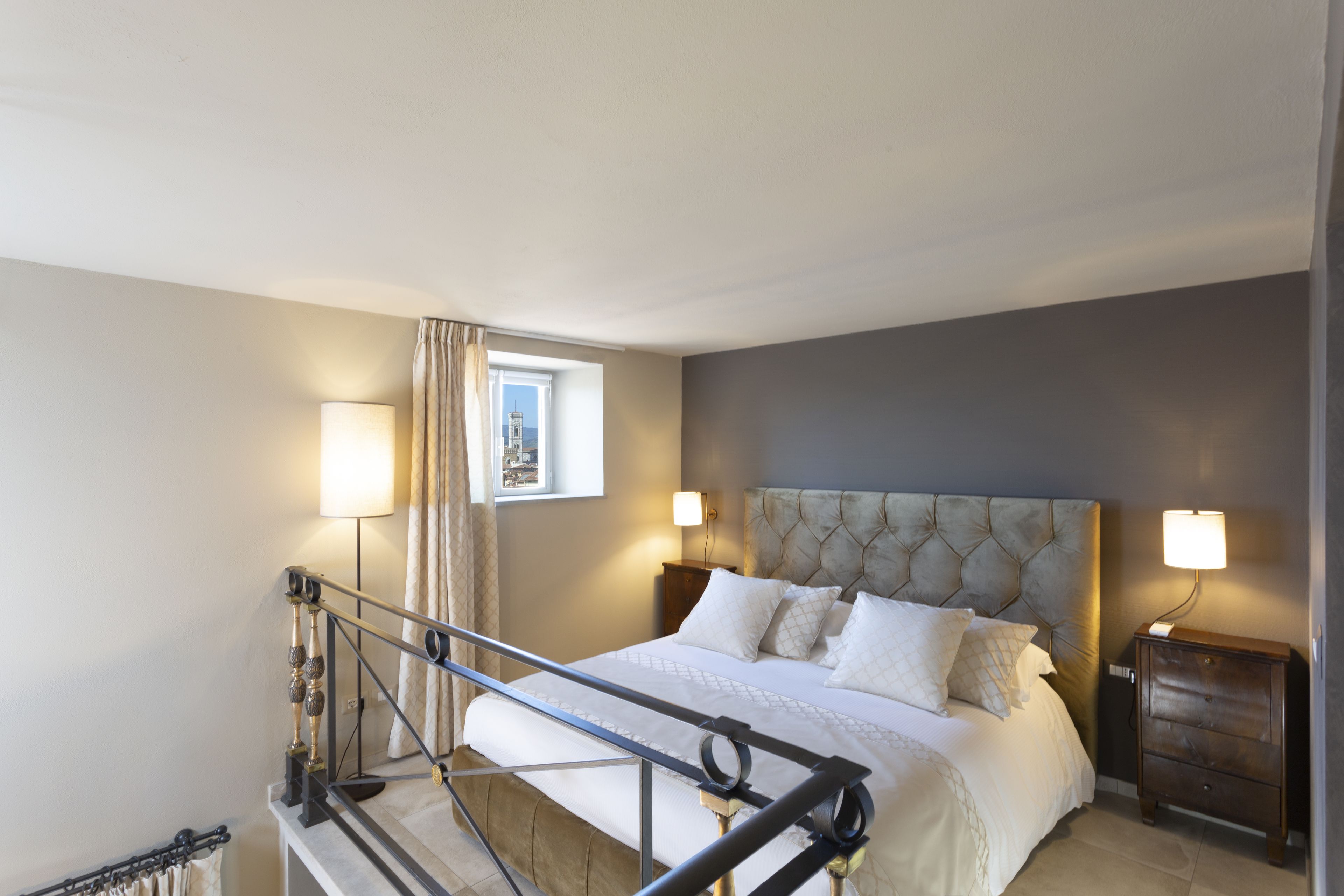 Une chambre à coucher avec un lit, des tables de chevet et une fenêtre.