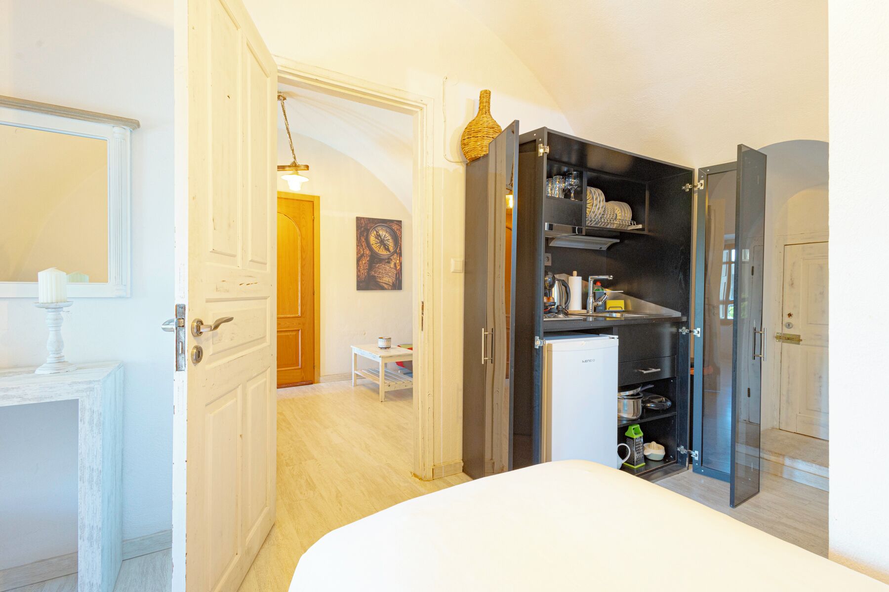 A compact bedroom with a bed, a small table, and a wardrobe.