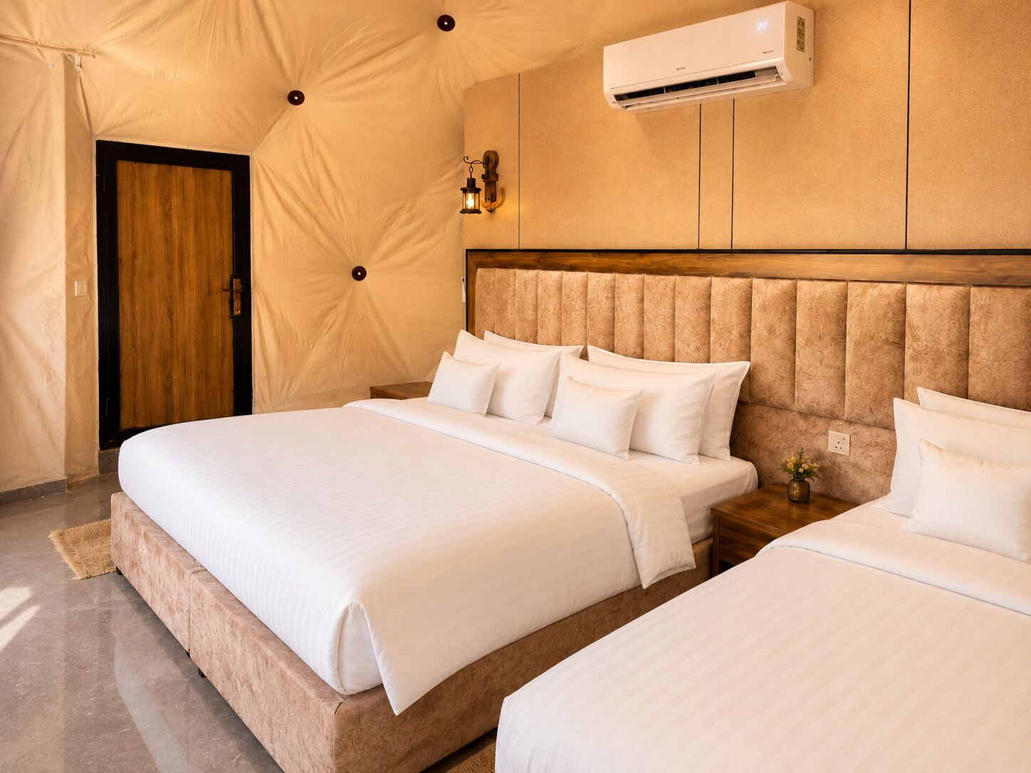 Una habitación de hotel con una cama grande, un equipo de aire acondicionado de pared y una puerta de madera.