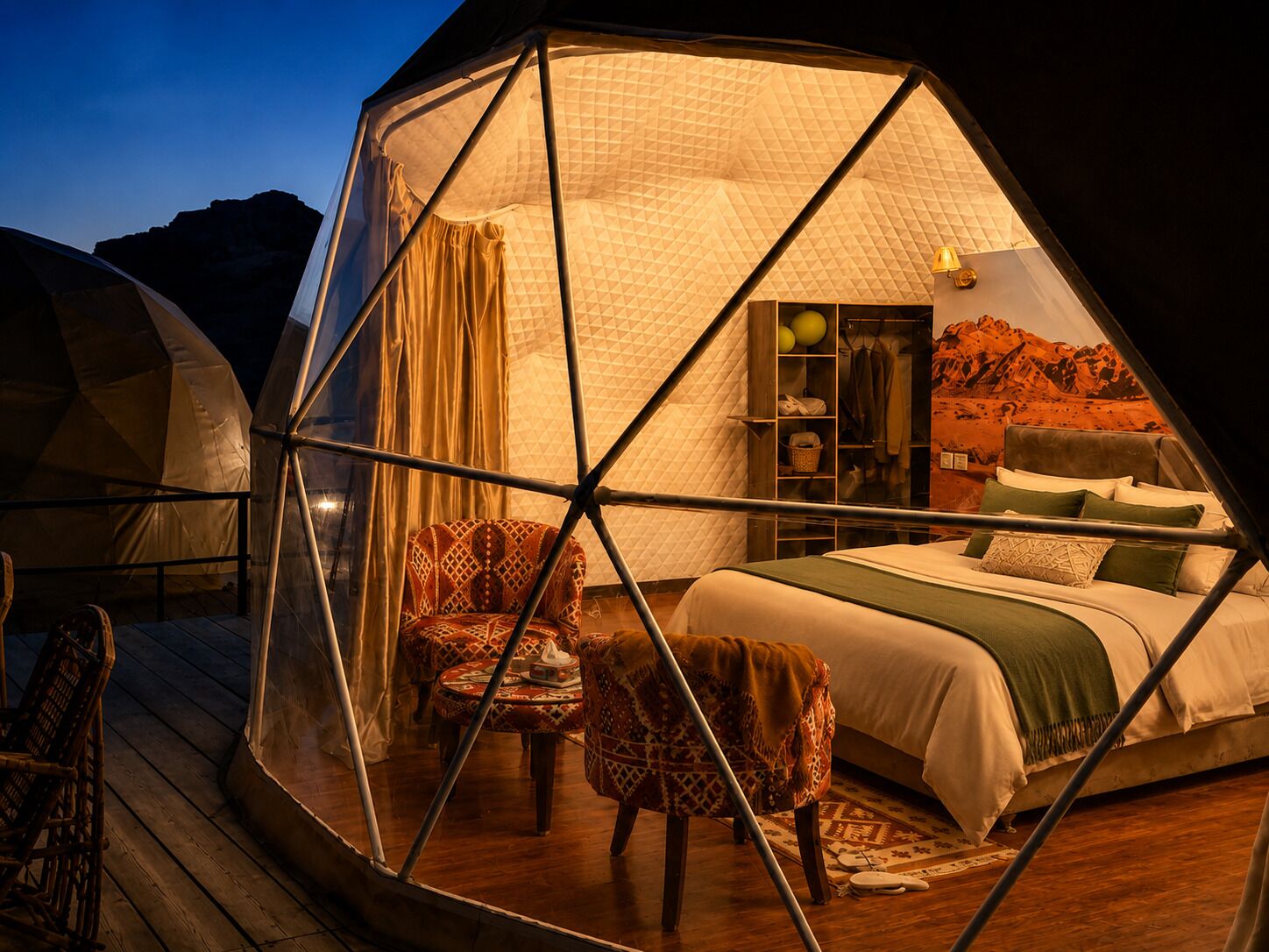 A hexagonal tent with a bed, chairs, and a wardrobe.