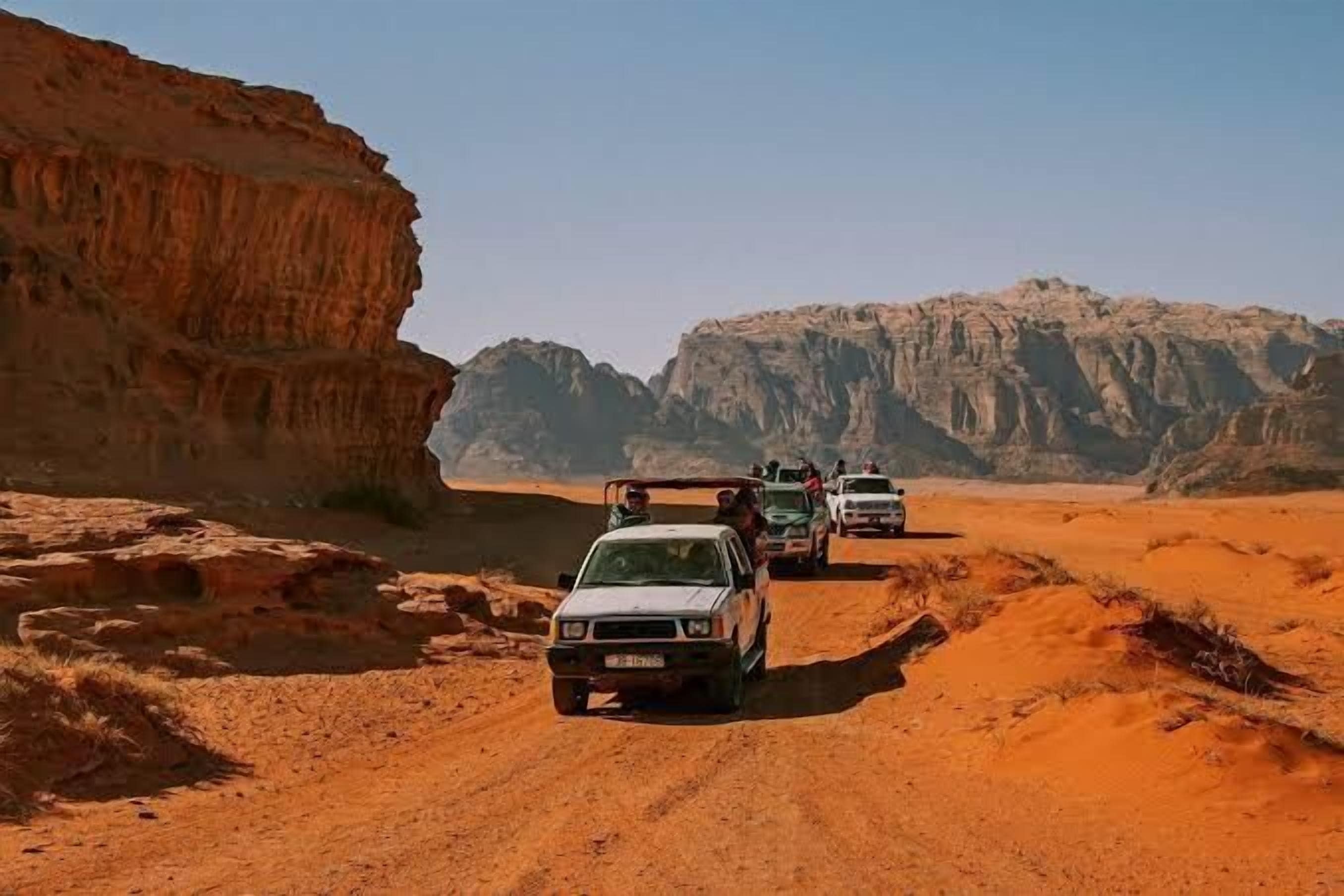 A desert road with vehicles.