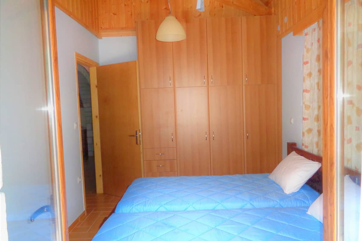 Ein Schlafzimmer mit einem großen Bett, einem Holzschrank und einer Pendelleuchte.