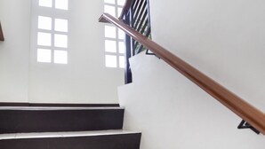 Eine Treppe mit Holzbalkonen und weißen Wänden.
